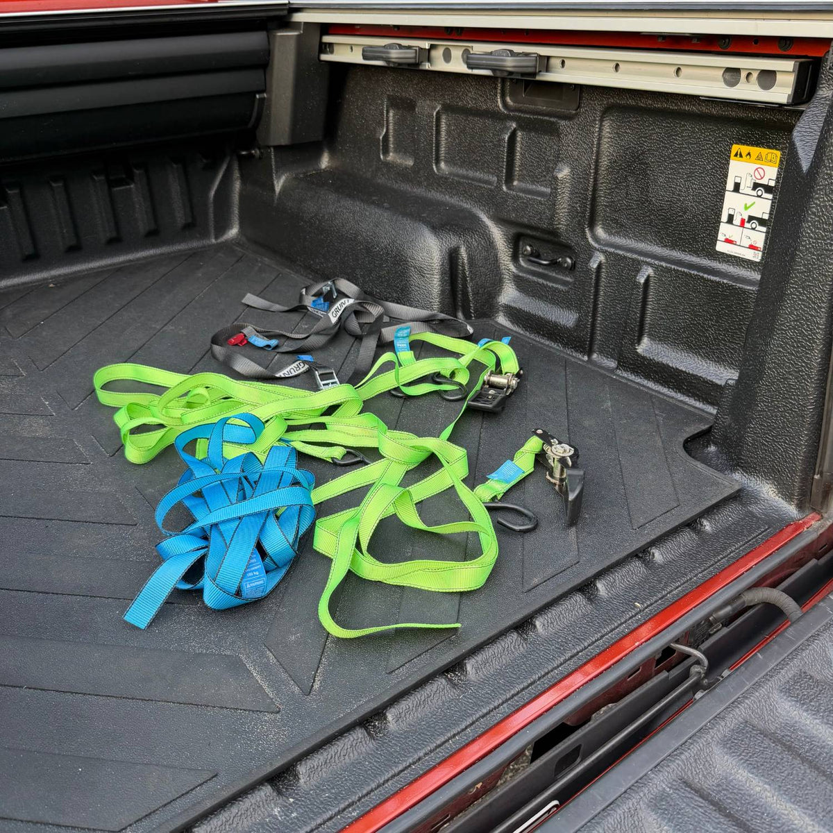 Loose tie-down straps tangled on the floor of a Ranger ute tub